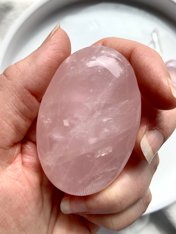 A close up view of our beautiful translucent pink Rose Quartz Palm Stones to hold in meditation