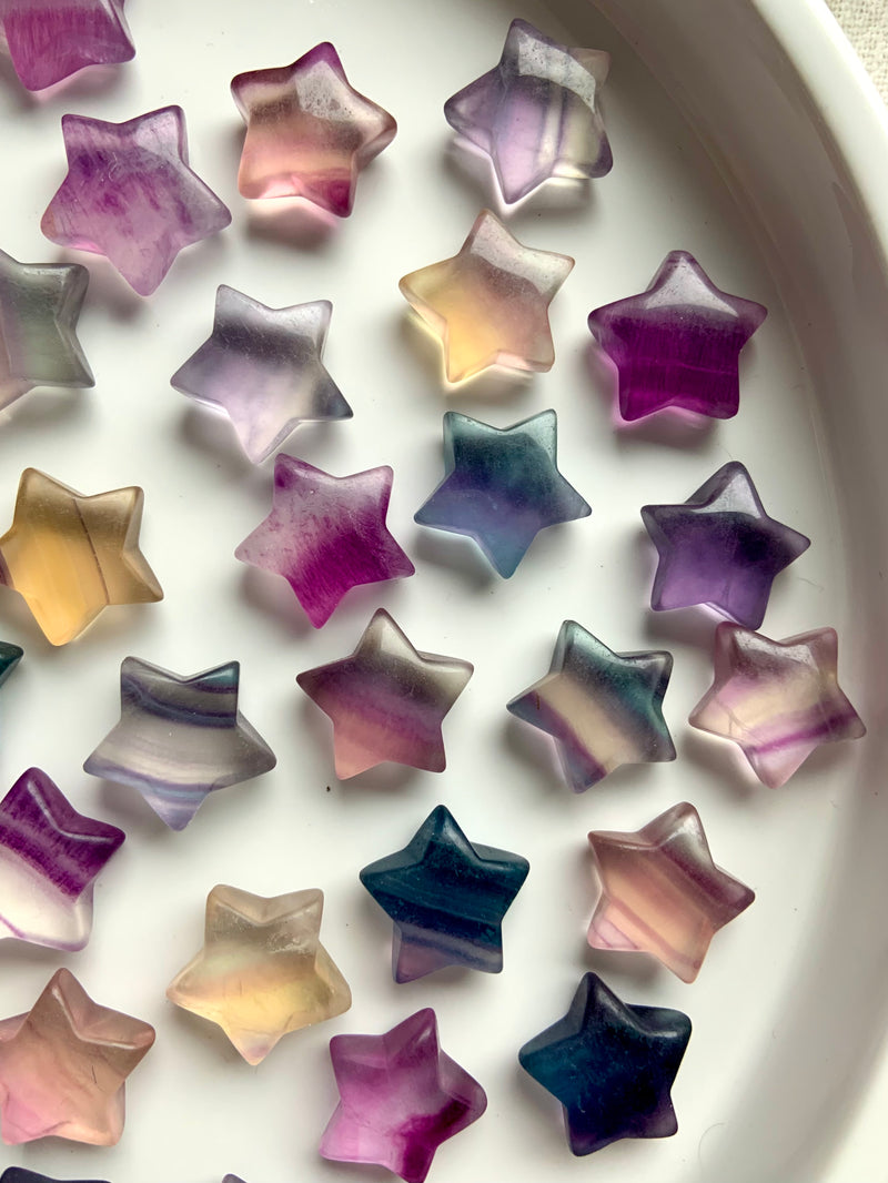 Colorful Rainbow Fluorite Crystal Star, Mini sized Star carving, Crystal shapes for Grids shown on a white plate