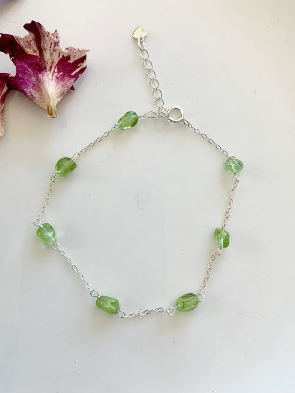 Dainty sterling silver Peridot gemstone bracelet with wrist size extender shown on a white background. Also available in gold filled