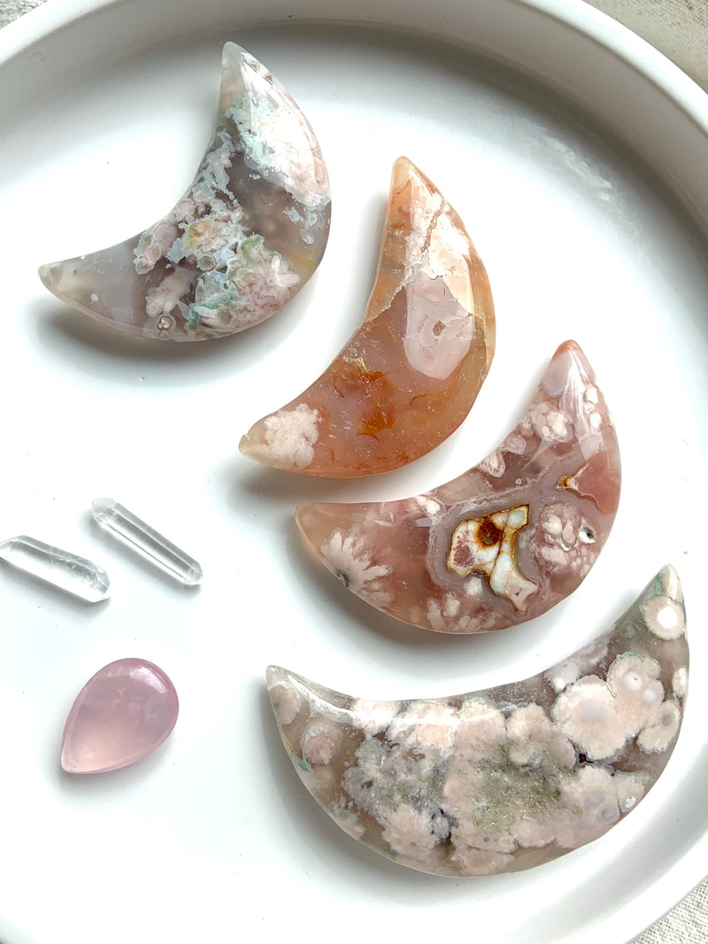 Big, palm sized Flower Agate Moons shown on a white plate with some smaller crystals. Choose your favorite!